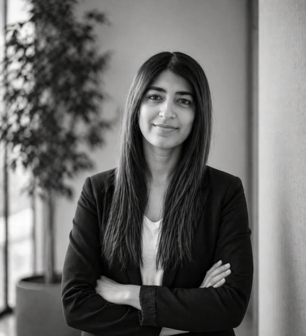 Black-and-white portrait of Dr. Tameer, a licensed clinical psychologist, in a dark blazer, arms calmly crossed